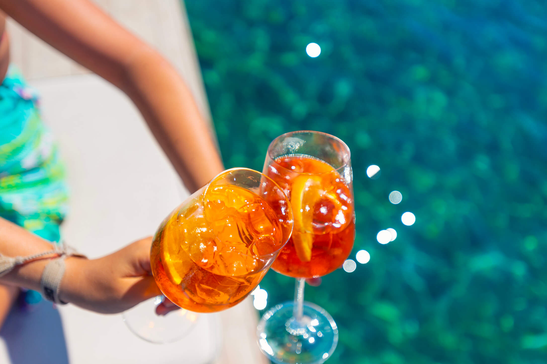 Tropical drinks clinking by pool