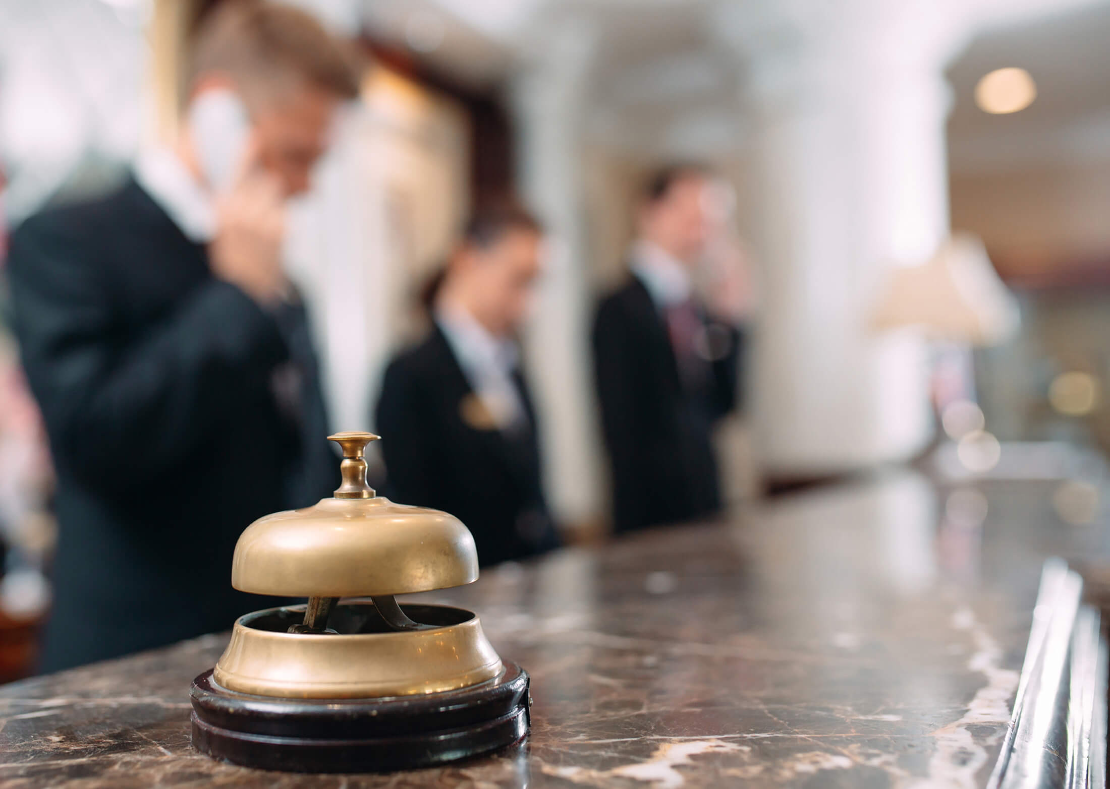 Bell on front lobby counter with workers in the background