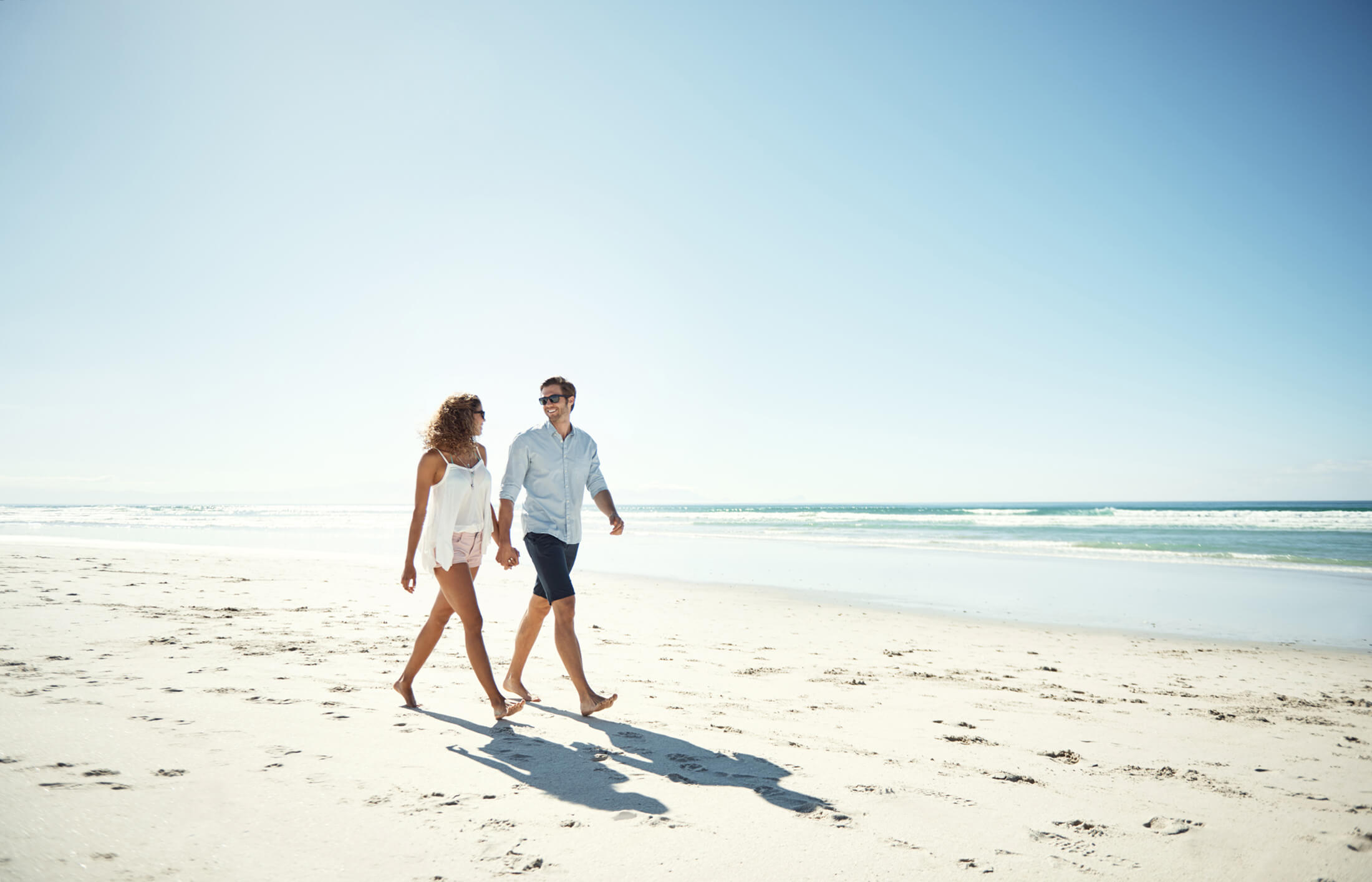 A couple walking on the beach at Pensacola Beach Resort
